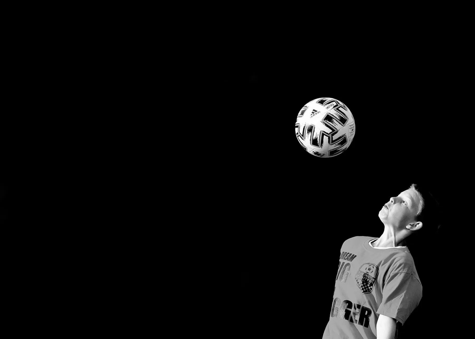 A Burlington United player keeping their eye on the ball