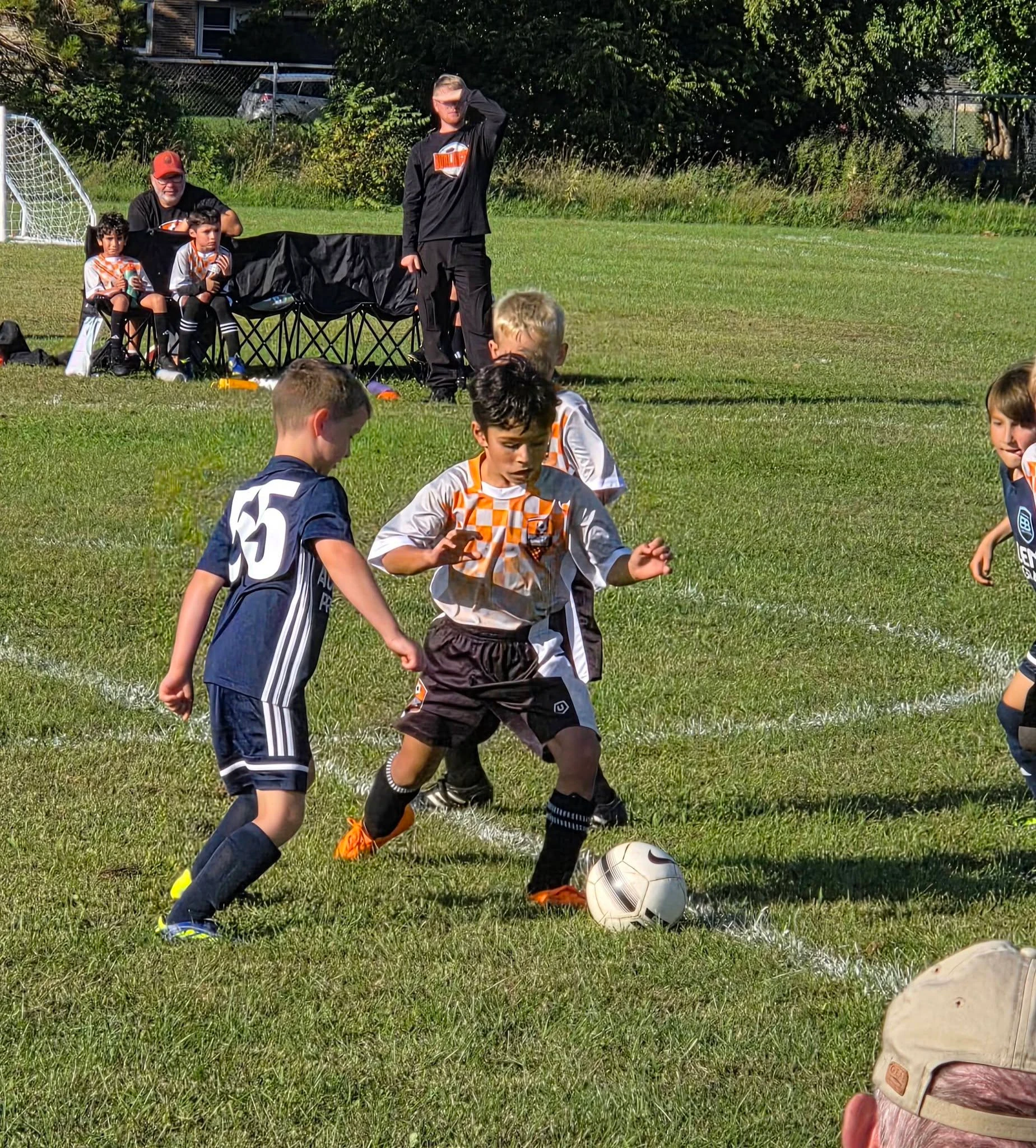 BUSC 8U Boys Orange players working for possession during a match.